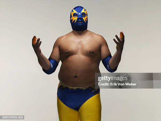 man wearing wrestler costume, holding hands up - wrestling fotografías e imágenes de stock