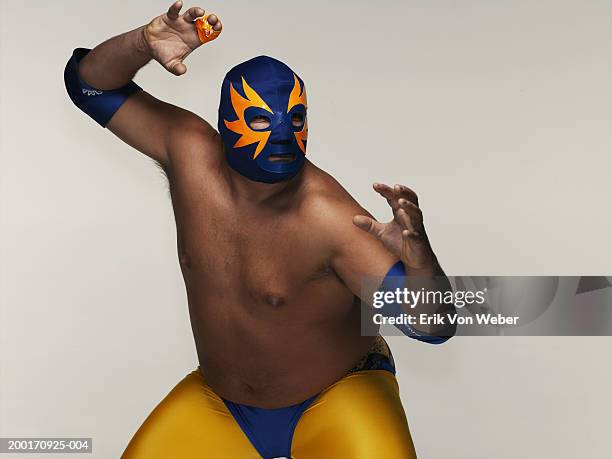 man wearing wrestler costume and mask, in wrestling position - aggression studio stock-fotos und bilder