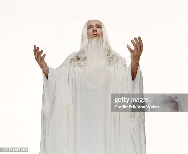 senior man wearing white robe with hands in air, looking up - robe stockfoto's en -beelden