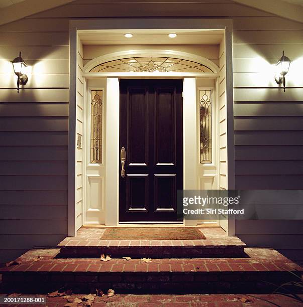 front door of house with lights at night - front door stock pictures, royalty-free photos & images