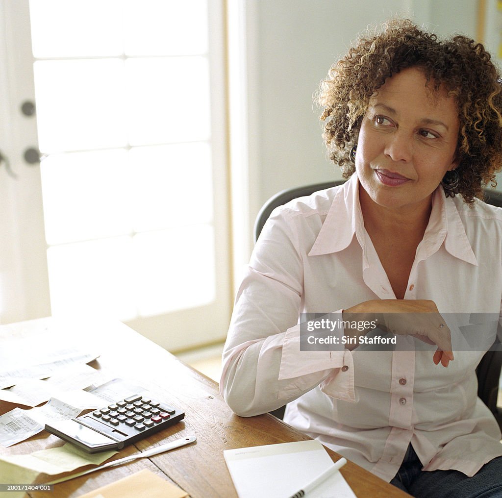 Mature woman doing finances in  home office, portrait