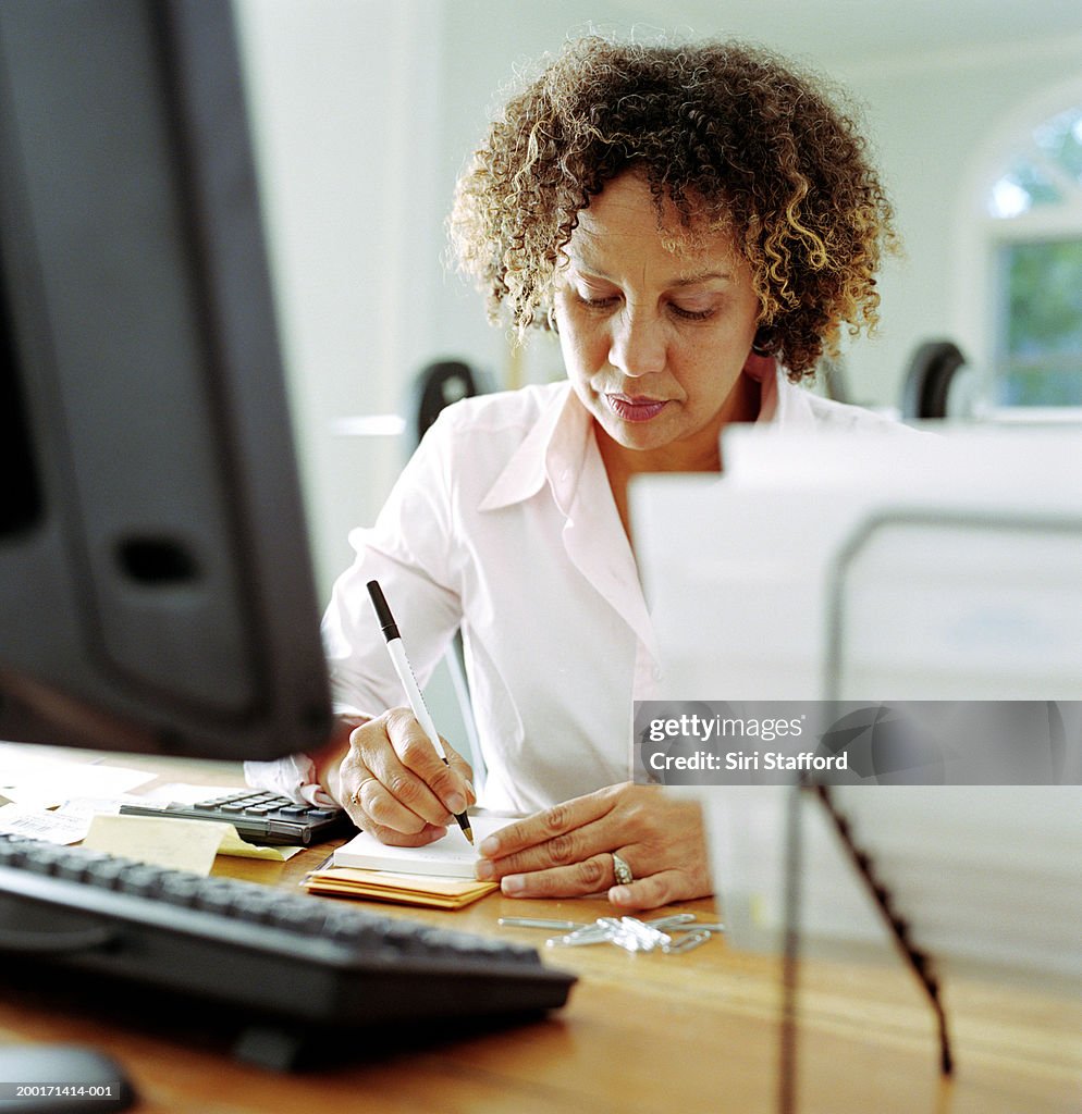 Mature woman doing finances in home office