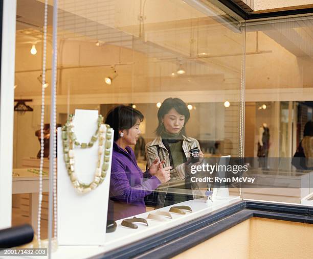 mother and daughter shopping in jewelry store, view through window - jewellery shopping stock pictures, royalty-free photos & images