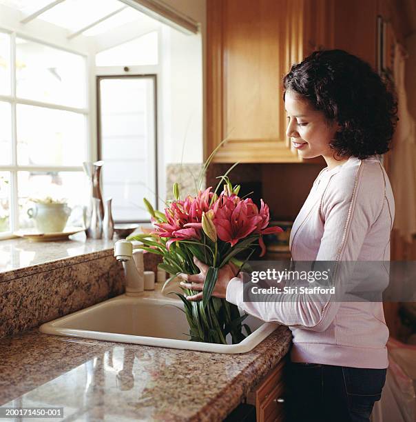 woman holding stargazer lilies in sink - lilium stargazer - fotografias e filmes do acervo