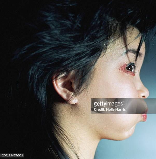 young woman puffing cheeks out, profile - stoneplus9 ストックフォトと画像