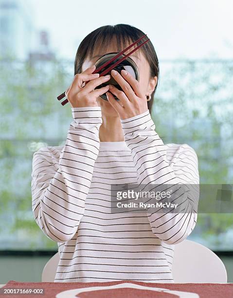 young woman eating bowl of miso soup - adult eating no face stock pictures, royalty-free photos & images
