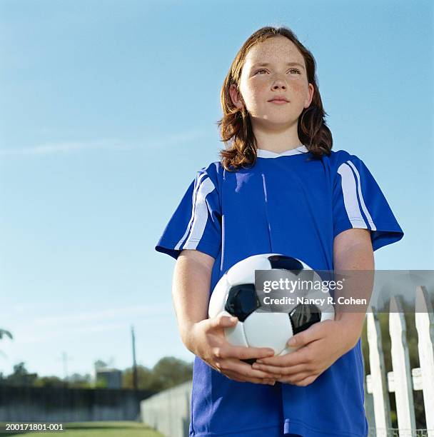 girl (8-10) holding soccer ball, low angle view - 8 ball stock-fotos und bilder