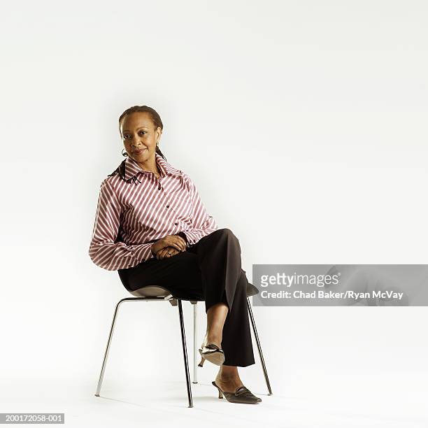 mature woman sitting in chair, portrait (digital enhancement) - legs crossed at knee stock pictures, royalty-free photos & images