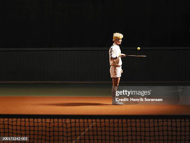 male tennis player bouncing ball on racket, night, side view - fitness solitude stock pictures, royalty-free photos & images