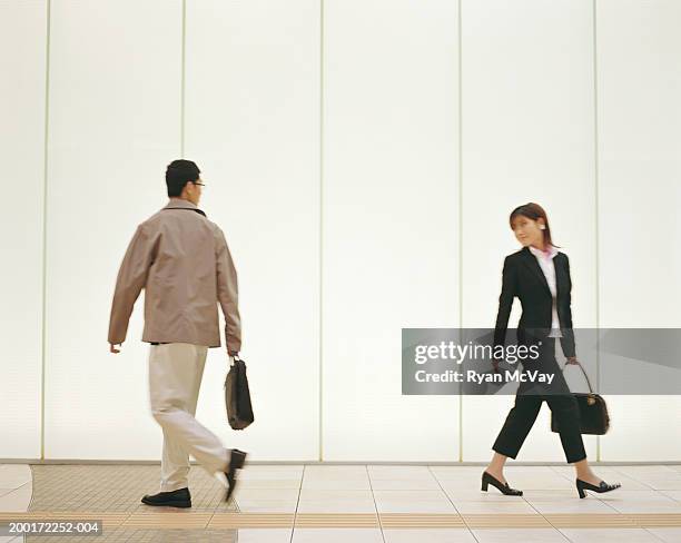 man and woman walking down corridor, looking over shoulders, side view - 經過 個照片及圖片檔