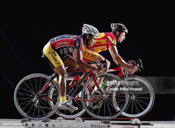 two male cyclist riding bicycles on rollers, side view - track cycling stock pictures, royalty-free photos & images