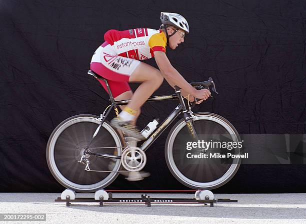 male cyclist riding bicycle on rollers (blurred motion) - 單車衫 個照片及圖片檔