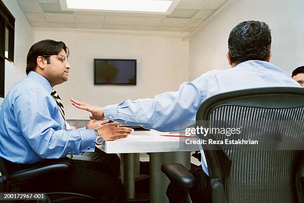 businessmen in meeting, one restraining colleague from speaking - rejection stock pictures, royalty-free photos & images