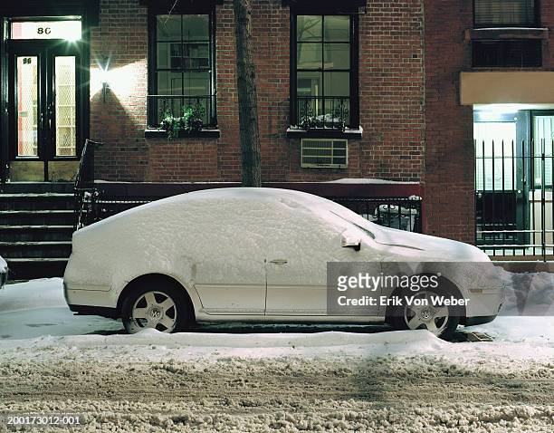 snow covered car on city street in front of house - immobile stockfoto's en -beelden
