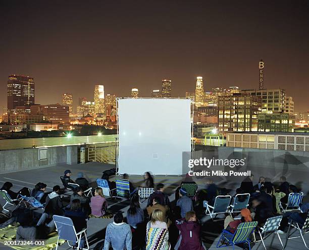 people on rooftop at night, sitting in front of projection screen - the uptown theater stock pictures, royalty-free photos & images