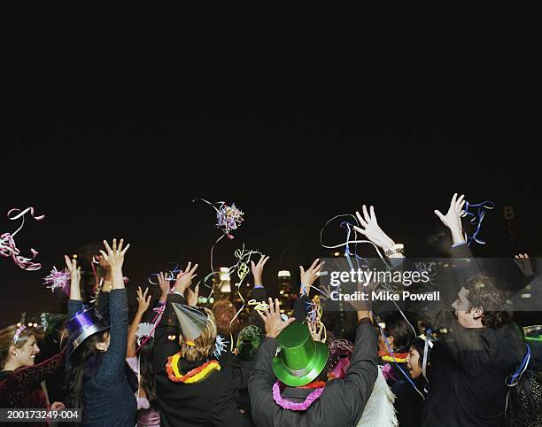 people celebrating on rooftop at new years eve party, rear view - happy new year ストックフォトと画像