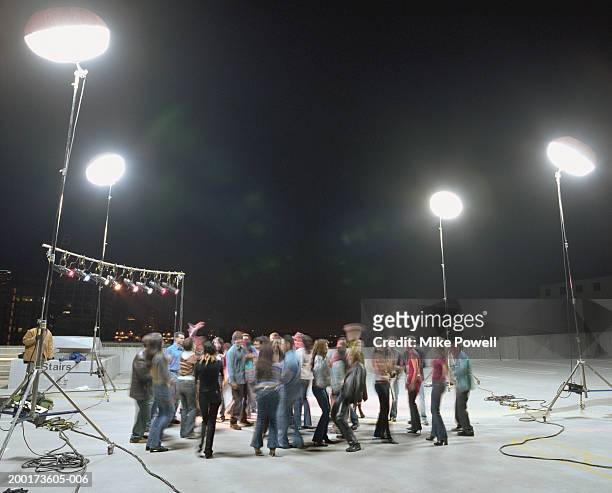 group of young adults dancing at rooftop set (blurred motion) - film set stock pictures, royalty-free photos & images