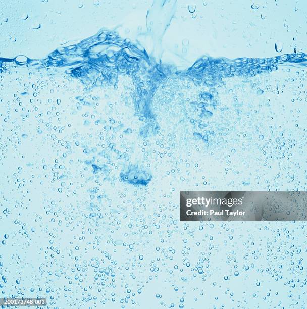 mineral water being poured into container, close-up - sprudelgetränk stock-fotos und bilder