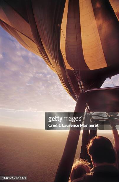 father and daughter (6-8) in hot air balloon, sunrise - air balloon stock pictures, royalty-free photos & images