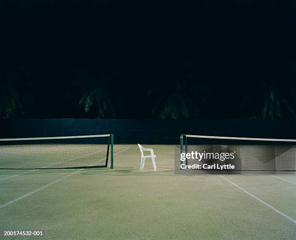 plastic chair between two tennis courts, night - テニスネット ストックフォトと画像