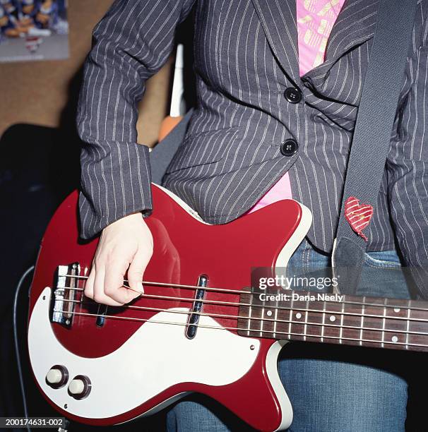 young woman playing bass guitar, mid section - bass guitar stock pictures, royalty-free photos & images