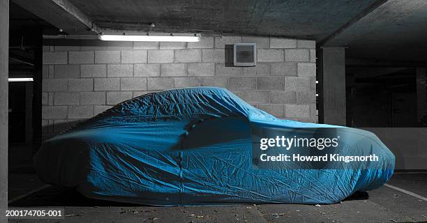 covered car in underground car park - covered car photos et images de collection