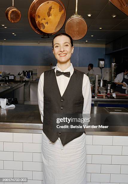 waitress standing by kitchen, smiling, portrait - 蝶ネクタイ ストックフォトと画像