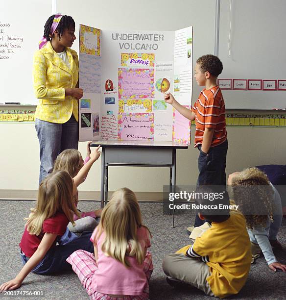 teacher and students (6-8) watching boy (6-8) give presentation - boy in briefs stock pictures, royalty-free photos & images