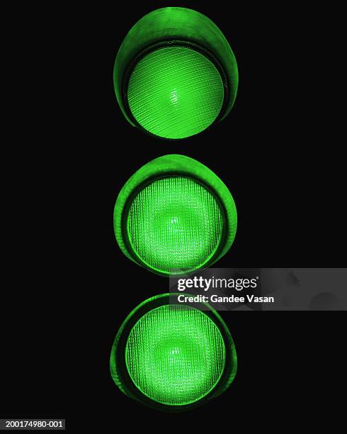 illuminated green traffic lights (digital enhancement) - semaforo fotografías e imágenes de stock