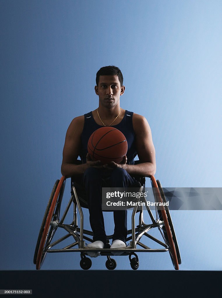 Paraplegic male athlete holding basketball, portrait