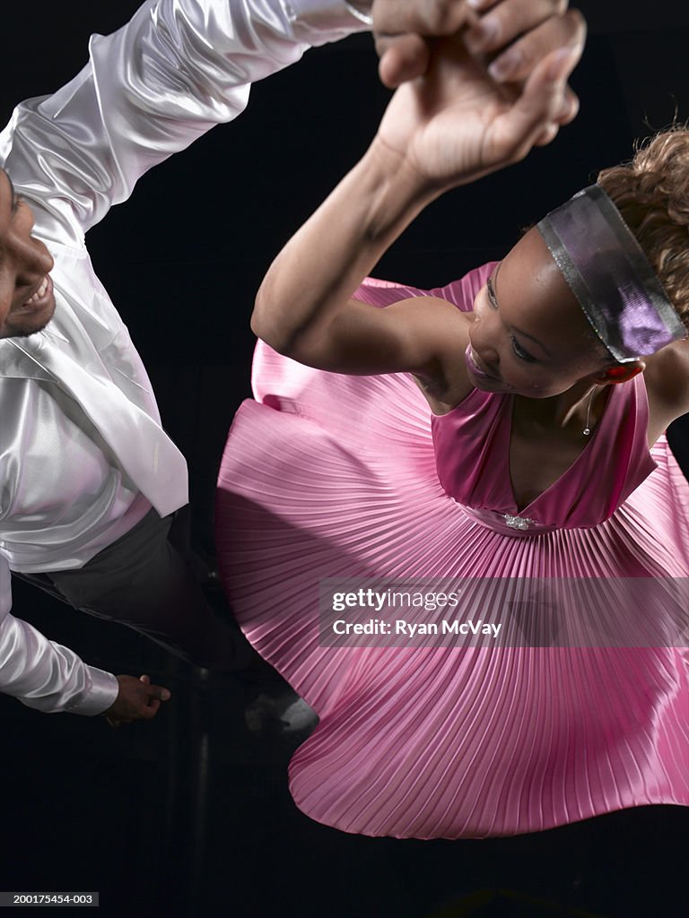 Man spinning woman on dance floor, elevated view