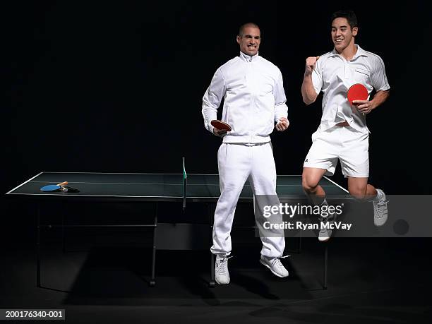 two young men celebrating table tennis victory - trainingsanzug stock-fotos und bilder