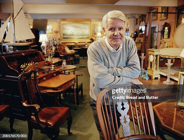 mature man leaning on chair in antique shop, portrait - man in antique shop stock pictures, royalty-free photos & images