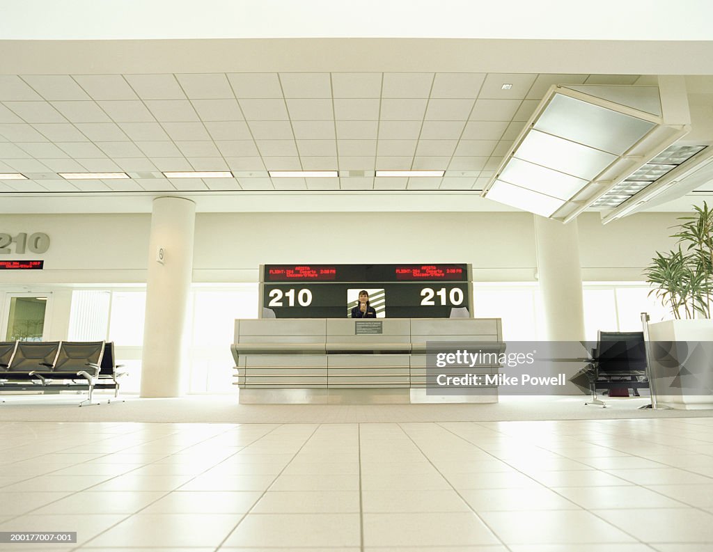 Airline attendant at check-in counter, low angle view