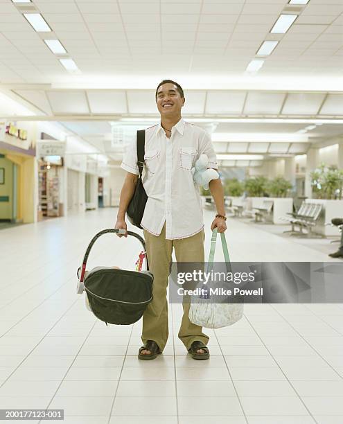 young man carrying baby carriage and bags in airport - baby bag stock-fotos und bilder