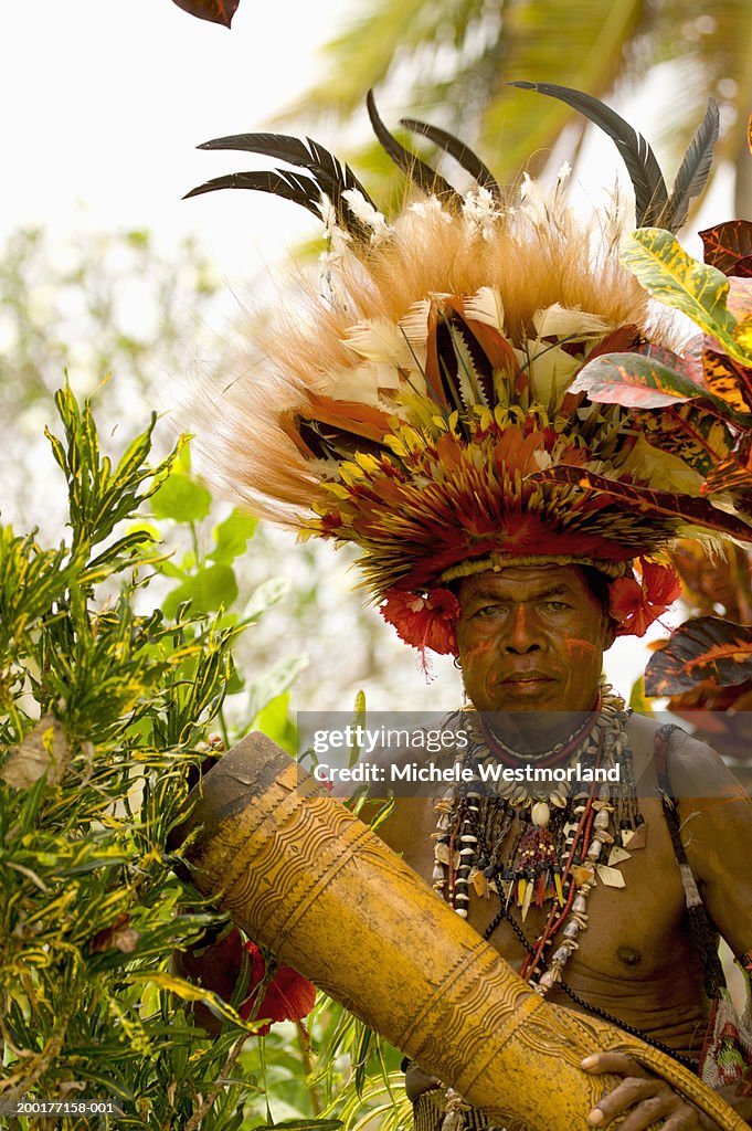 Man wearing headdress, holding drum, portrait