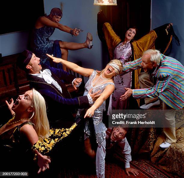 group of adults at fancy dress party in living room - party aftermath stock-fotos und bilder