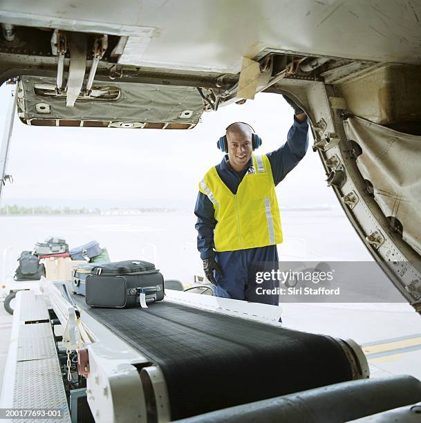 airport ground technician loading luggages into cargo hold of aircraft - open day 1 bildbanksfoton och bilder