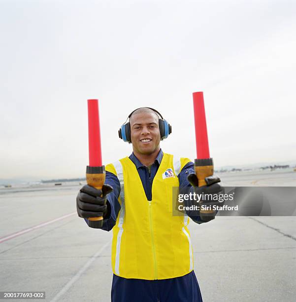 airport ground crew holding signaling sticks - air traffic control operator stock pictures, royalty-free photos & images