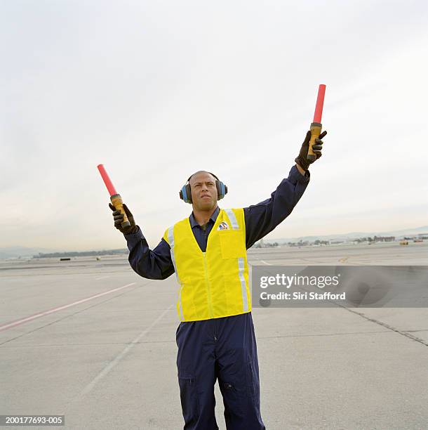 airport ground crew directing aircraft - air traffic control stock-fotos und bilder