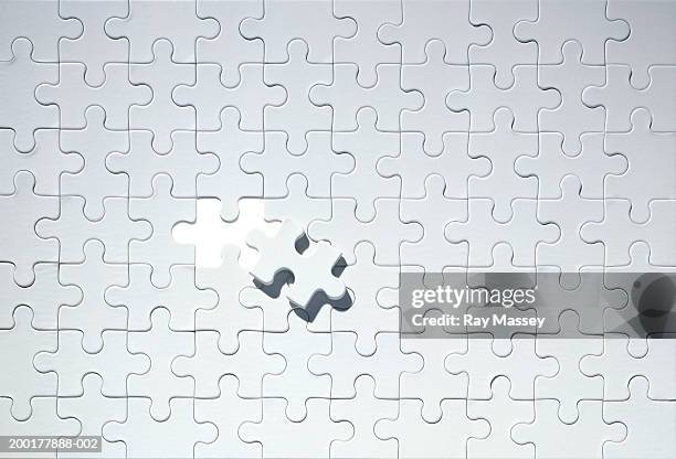 missing piece on grey jigsaw puzzle - puzzel stockfoto's en -beelden
