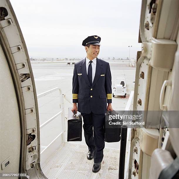 pilot carrying luggage into aircraft - captains day stockfoto's en -beelden