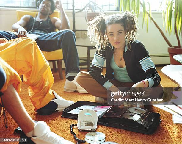 young people in room, woman on floor with cd case, portrait - cd imagens e fotografias de stock