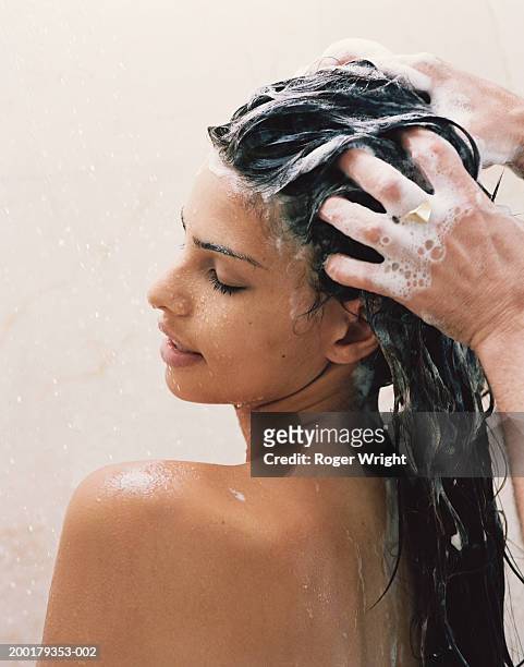 man washing young woman's hair, close-up - lavarse el cabello fotografías e imágenes de stock