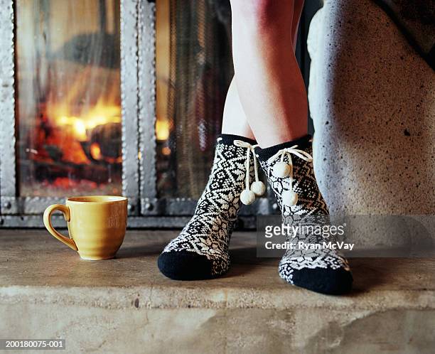 teenage girl (15-17) standing beside fireplace, low section - pés cruzados - fotografias e filmes do acervo