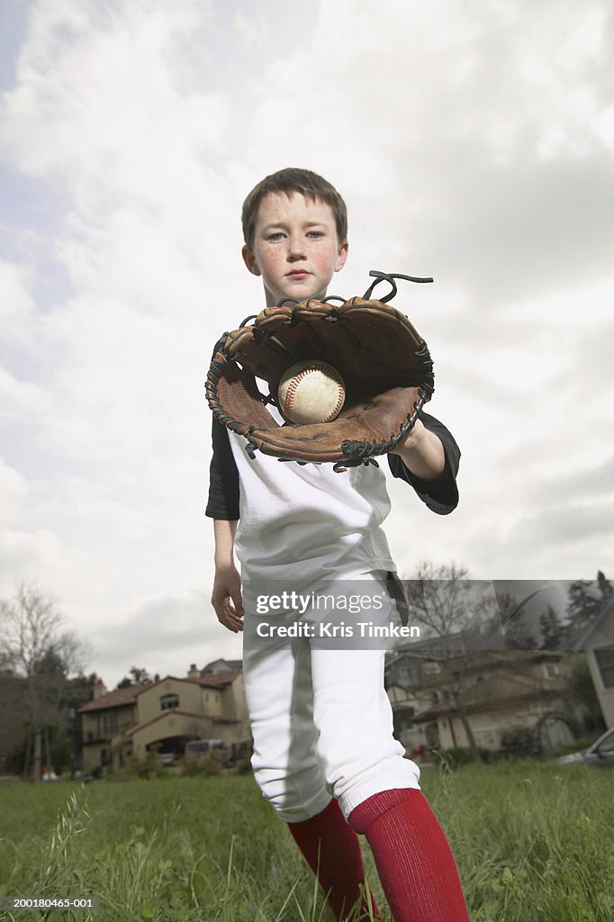 Boy (10-12) showing baseball in glove, portrait