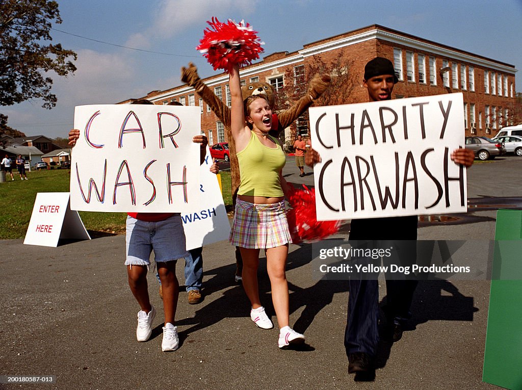 Group of teenagers (14-18) holding car wash signs girl cheering