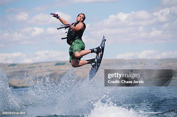man wakeboarding, view from boat - wakeboarden stock-fotos und bilder