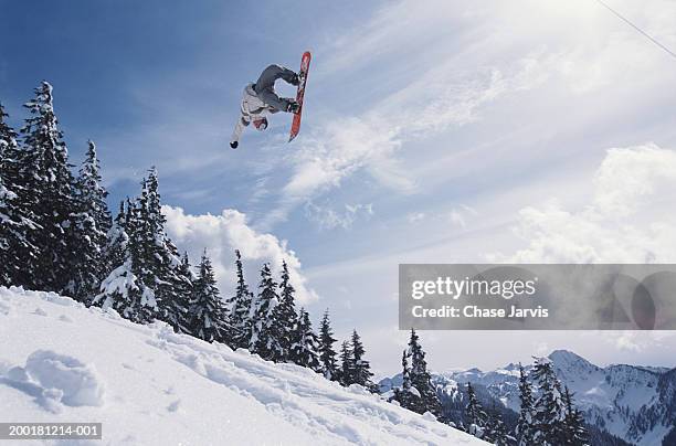 snowboarder performing jump, low angle view - boarders stock pictures, royalty-free photos & images