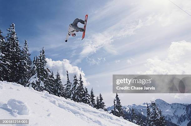 snowboarder performing jump, low angle view - snowboard jump bildbanksfoton och bilder